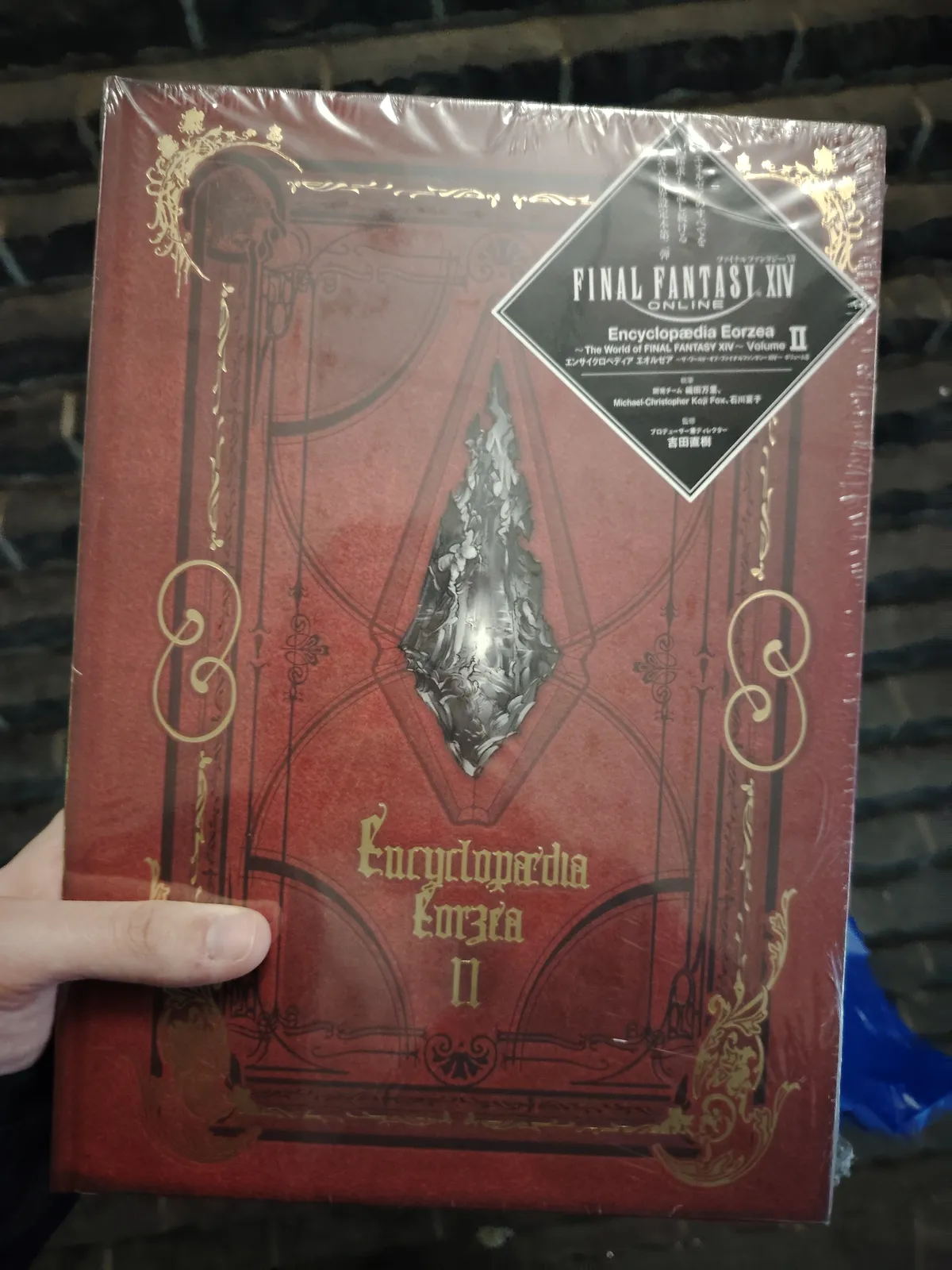 The encyclopedia eorzea II. It's a red hardcover book with a crystal in the middle of the cover, surrounded by some gold decorations