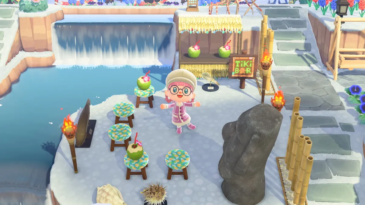 Slothra is in a tiki bar, with coconut drinks, fish models, a giant Easter Island head, and bamboo dividers.