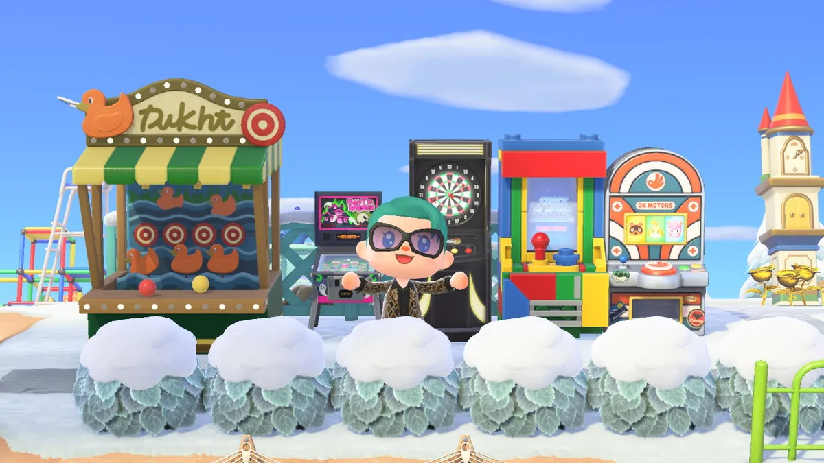 Slothra is standing in front of a range of games, including a shooting gallery, a pinball machine, an electronic dartboard, a Lego arcade game, and a Pocket Camp slot machine.