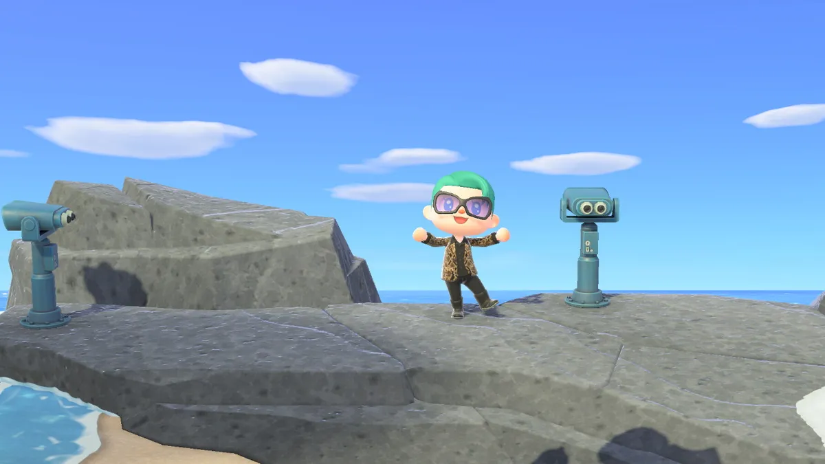 Slothra is standing on the rocks at the very far north east of the island, next to two tourist telescopes.