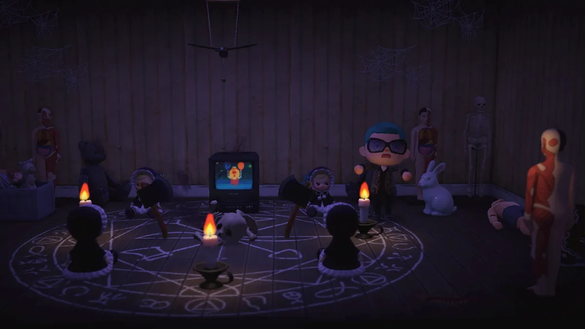 Glothra is standing in an attic room where there's a large chalk symbol drawn on the floor. There are candles and dolls arranged around the symbol, with a skeleton in the middle and a television behind the skeleton. There are also skeletons, toys, dummies, and anatomical figures around the room.