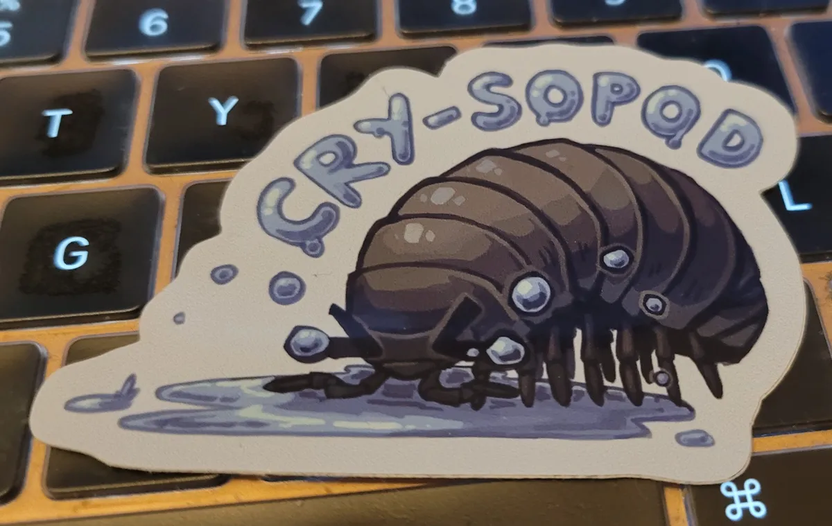 An illustration of a roly-poly (or woodlouse. or pill bug. or isopod.) who is dramatically crying into a puddle of tears. The text reads "cry-sopod".