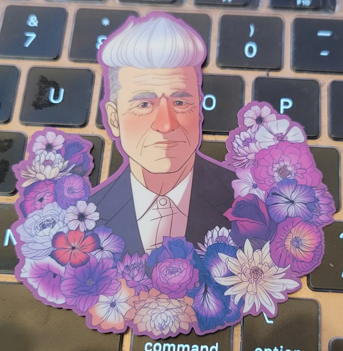 An illustration of David Lynch, with a flower garland along the bottom.
