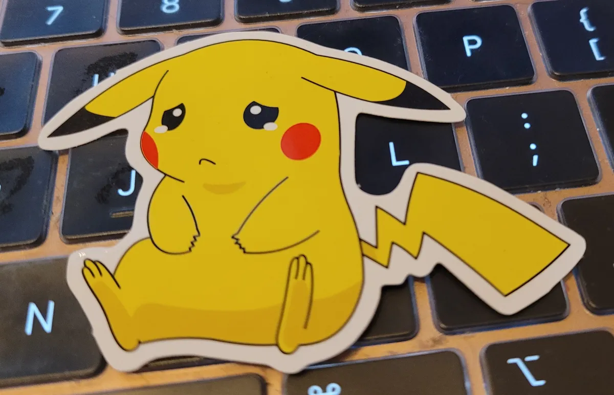A sticker of Pikachu sitting down forlornly, tears starting to glitter in his eyes, and a sad expression on his face.
