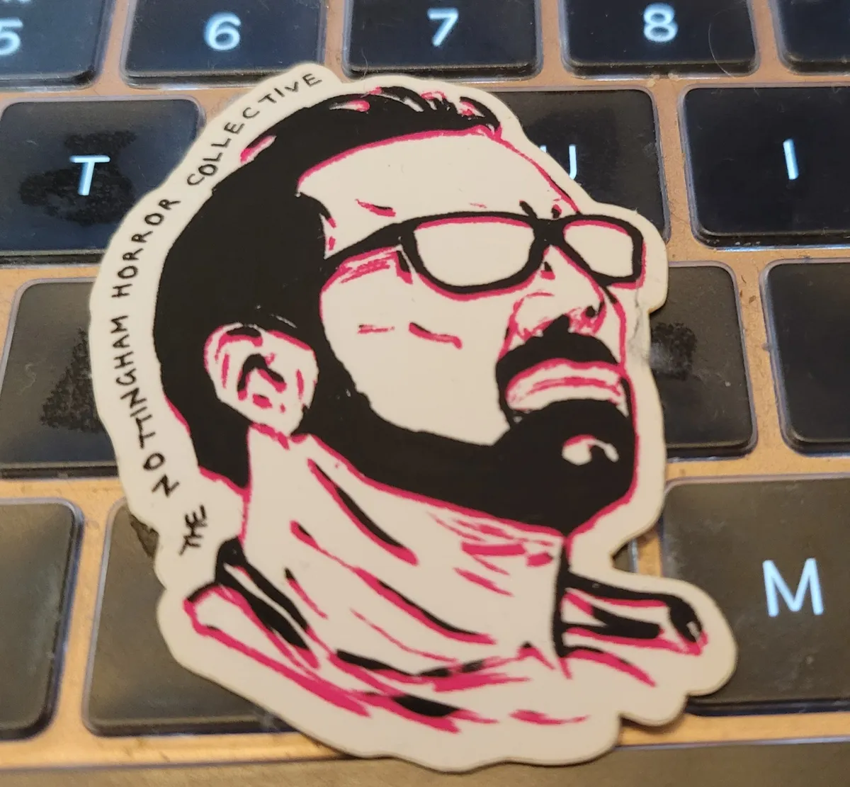 A black and white illustration of Nicholas Cage, with a beard and glasses, looking up in a side profile.