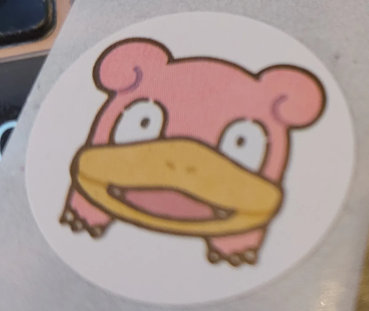 A cartoony image of a Pokémon Slowpoke's face