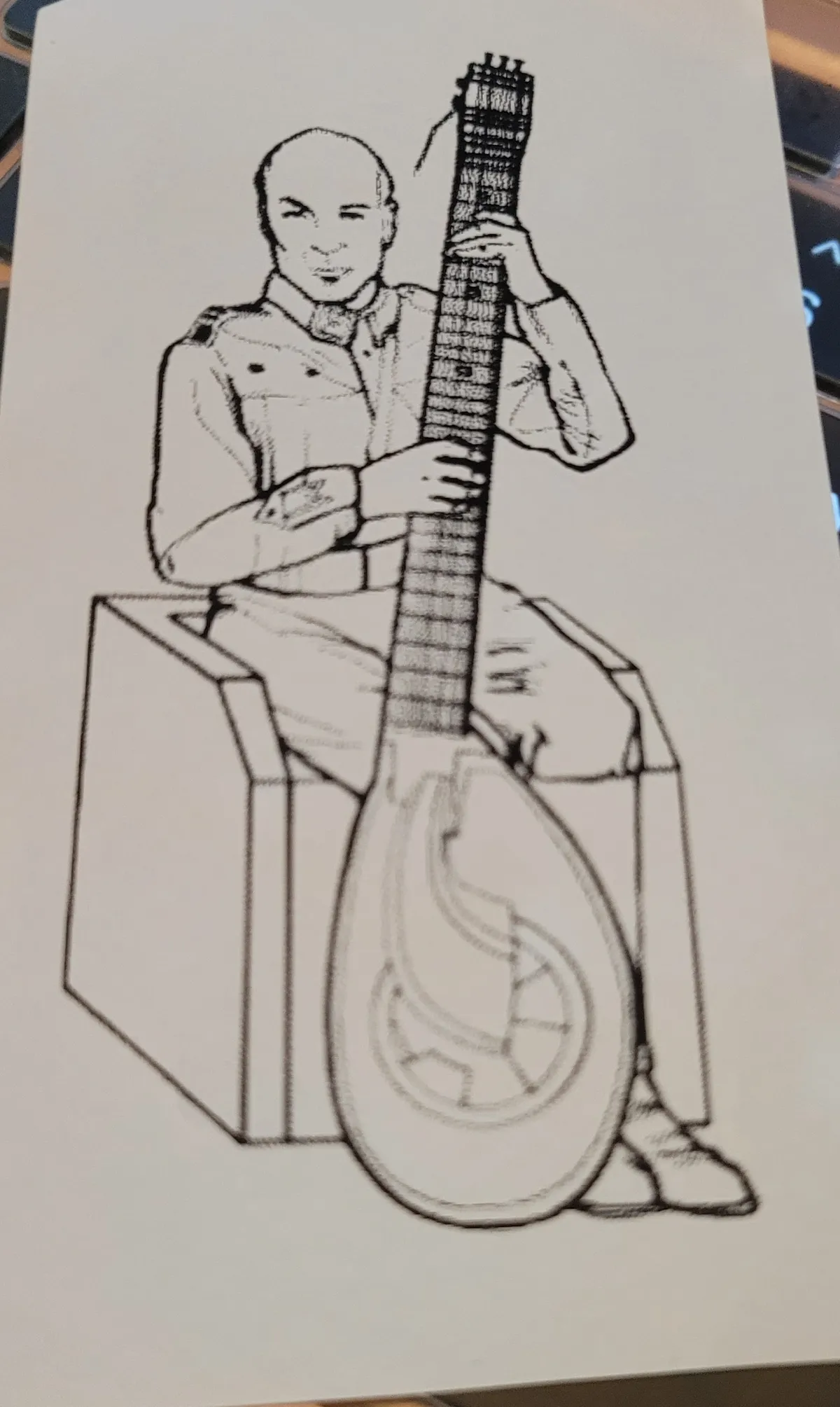 An illustration of Patrick Stewart as Gurney Halleck in Dune (1984), holding a baliset, a fictional stringed musical instrument based on a zither.