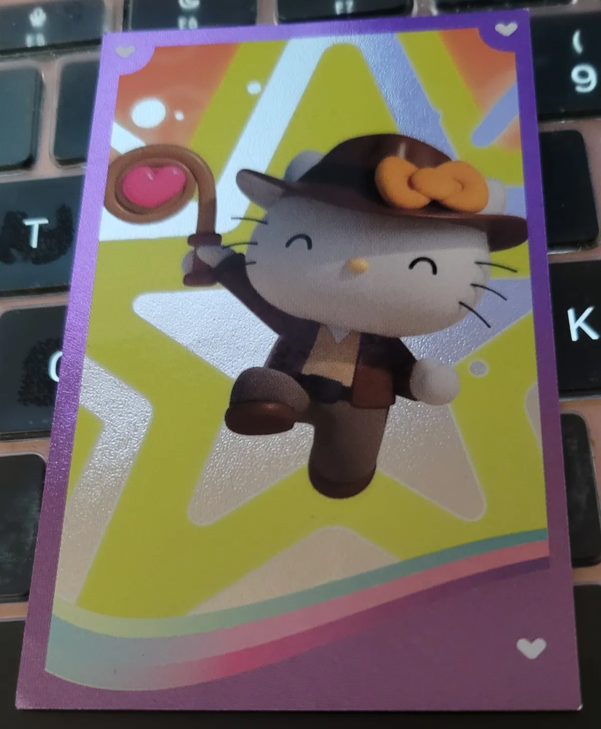 A shiny metallic sticker where Hello Kitty is dressed as Indiana Jones, complete with fedora and whip.