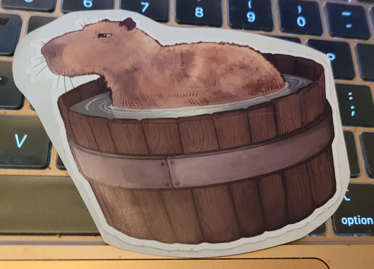 An illustration of a capybara in a wooden round bathtub, looking very unbothered.