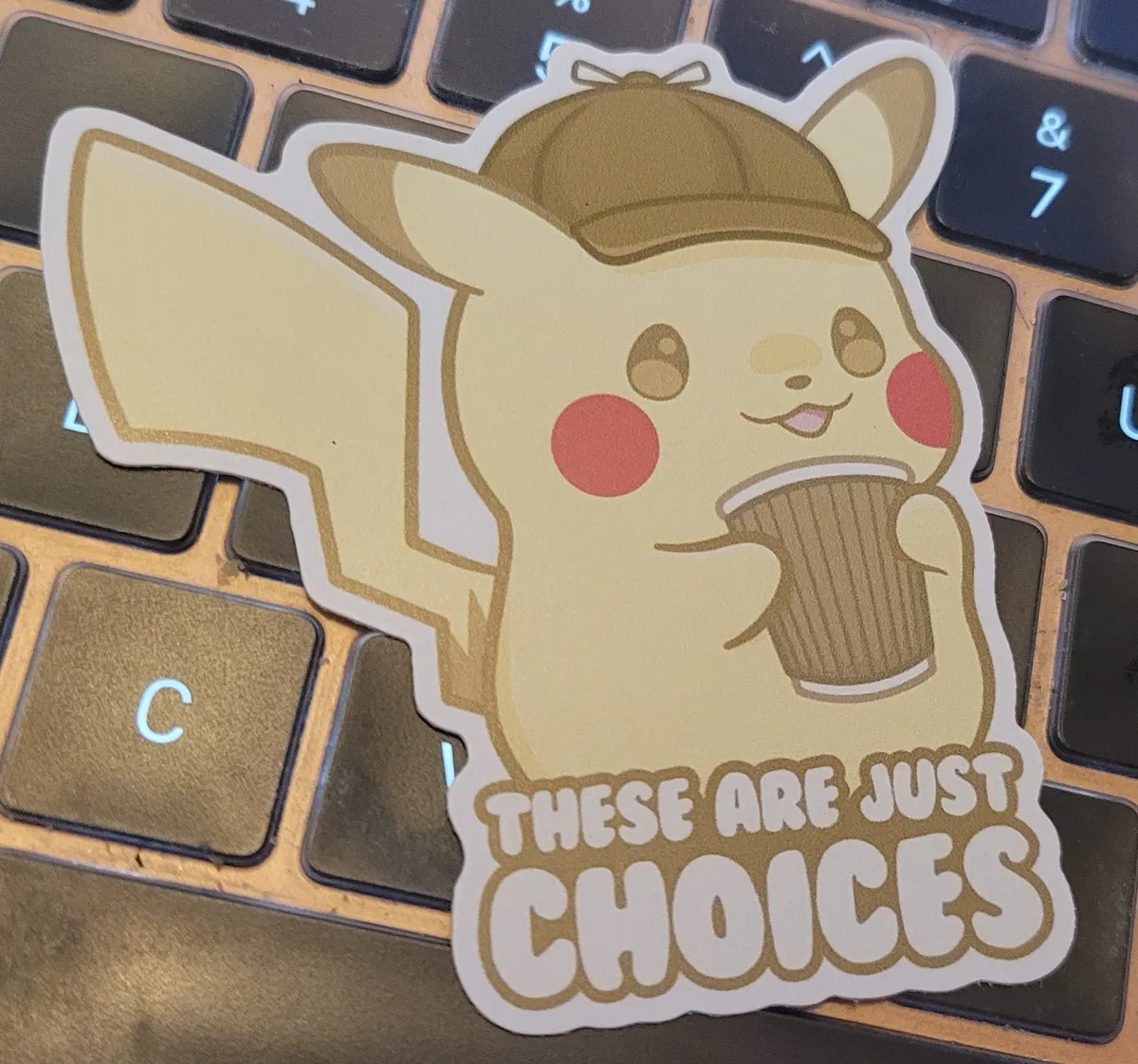 A cute illustration of Pikachu wearing his detective hat and holding a takeaway cup of coffee. Underneath him it says 