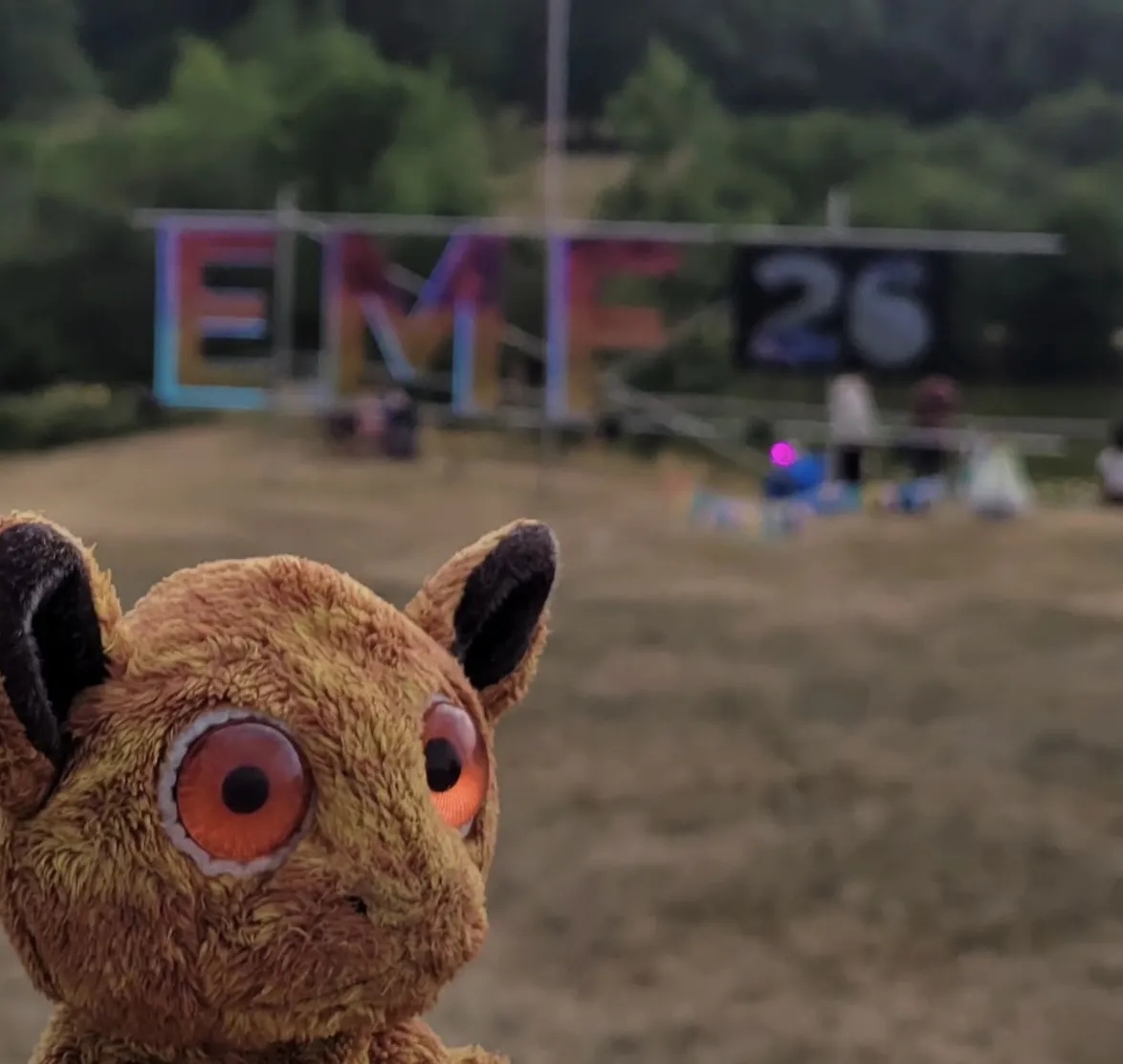 Lemur looking towards the right, with the giant EMF 26 sign blurry in the background