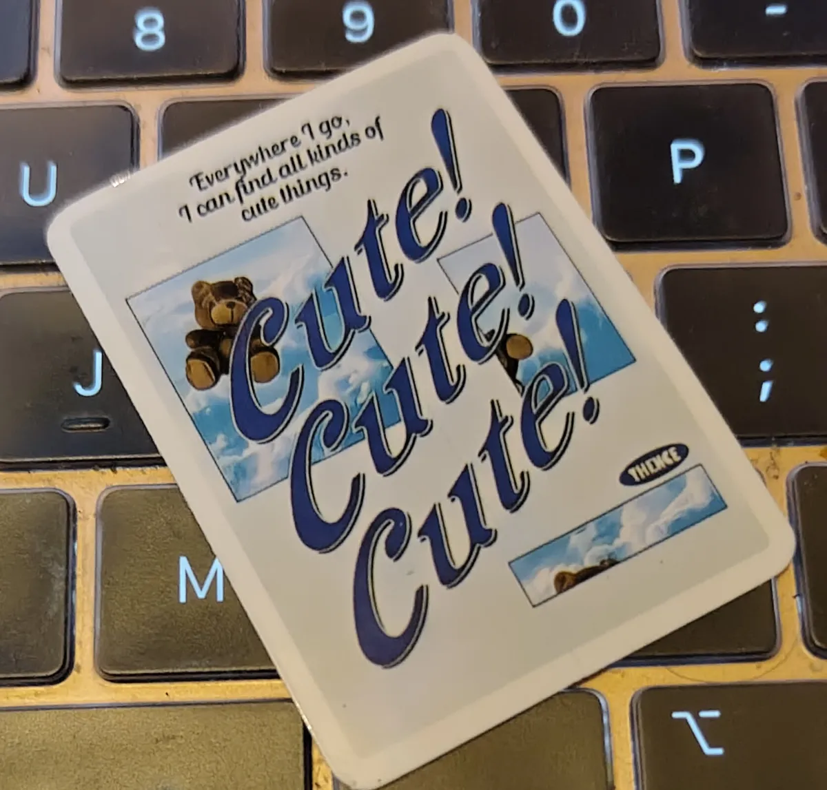 A rectangular sticker with a few rectangles of a toy bear in the air. The text over the rectangles reads