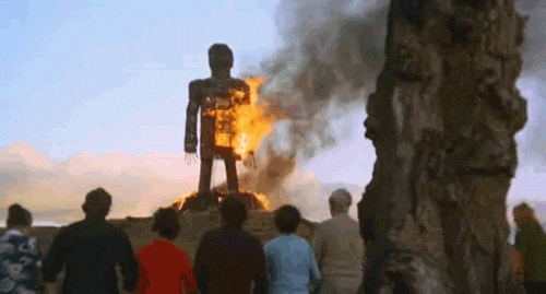 An animated GIF showing the finale of The Wicker Man (1973), with the Summerisle villagers rocking back and forth as they sing "Sumer is a-cumen in" while Officer Howie burns in the giant wicker man.