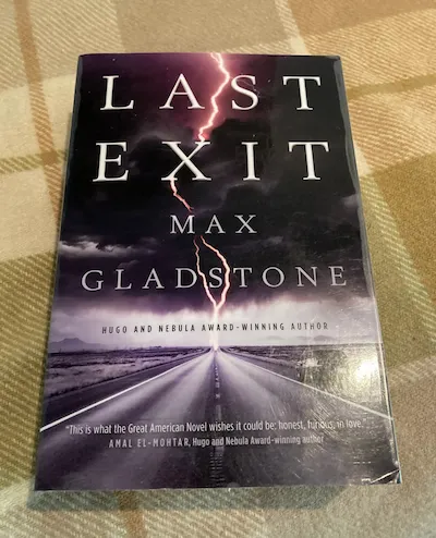 The cover for Last Exit by Max Gladstone, showing lighting blasting a road.