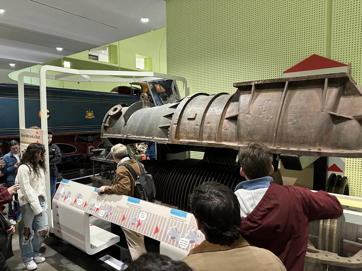 A group of students and their professor in front of a heat engine.