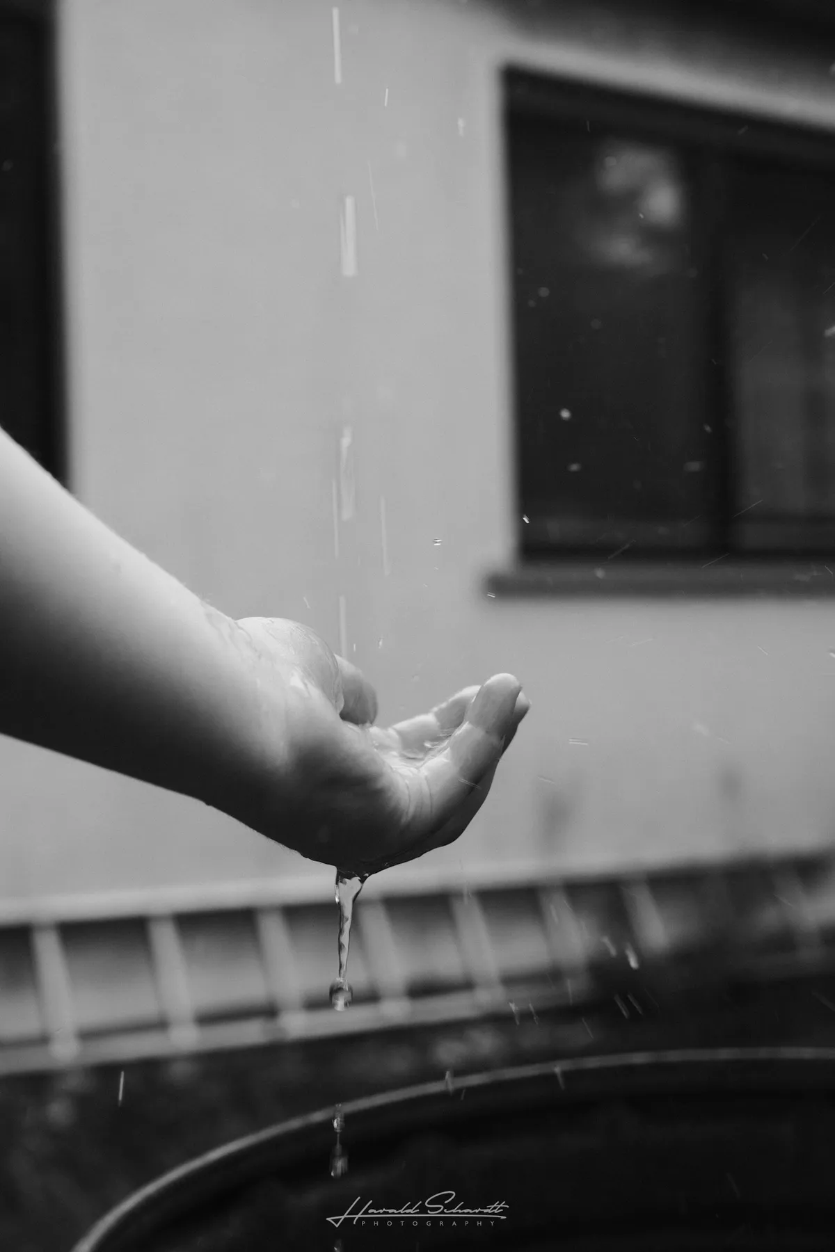 Hand catching raindrops during a summer rain shower.
