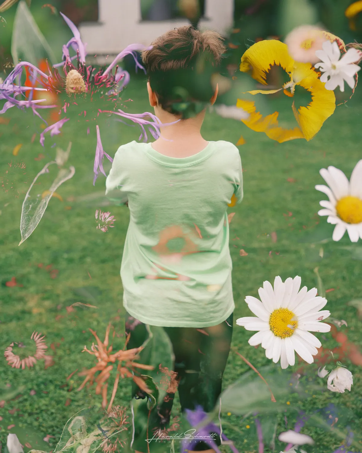Child seen through overlapping flower exposures in a garden.