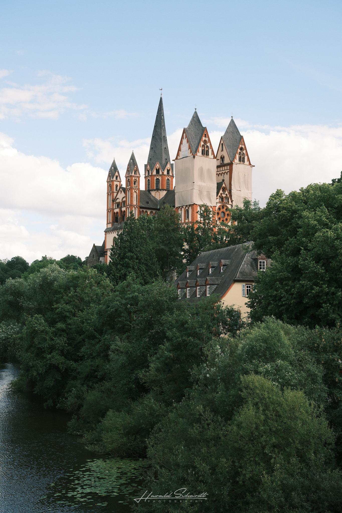 Limburg Cathedral rising above the trees beside the river.