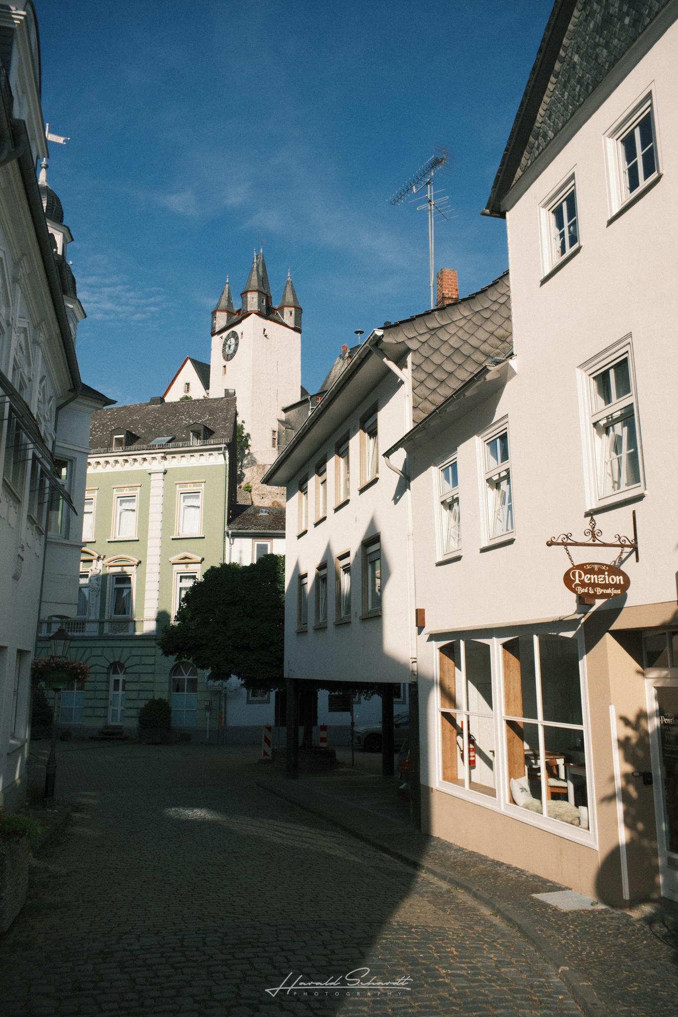 Street view toward the castle tower, half-timbered building with a Penzion Bed & Breakfast sign in the foreground.