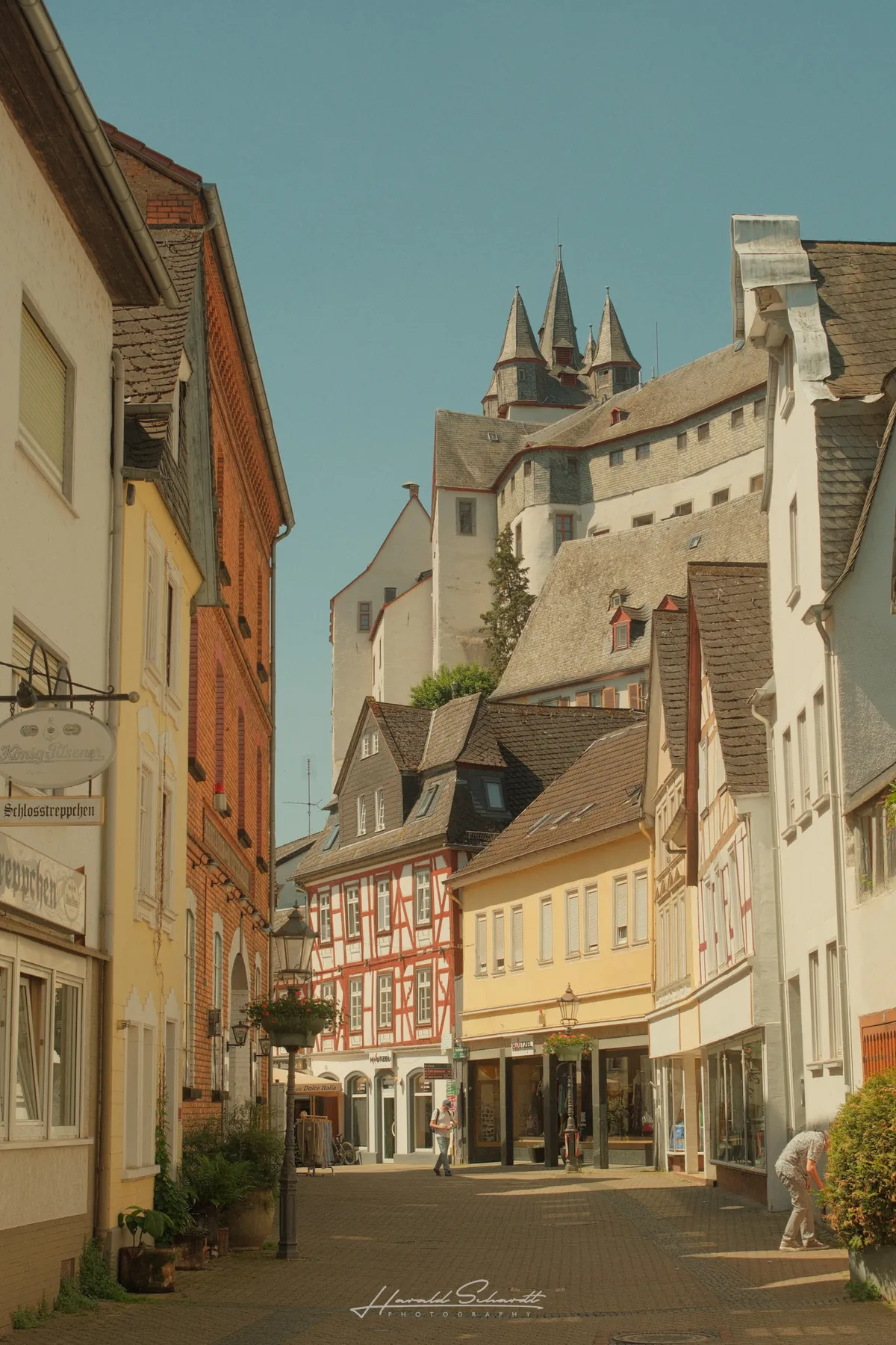 Diez old town street with half-timbered houses and the castle rising above the rooftops.