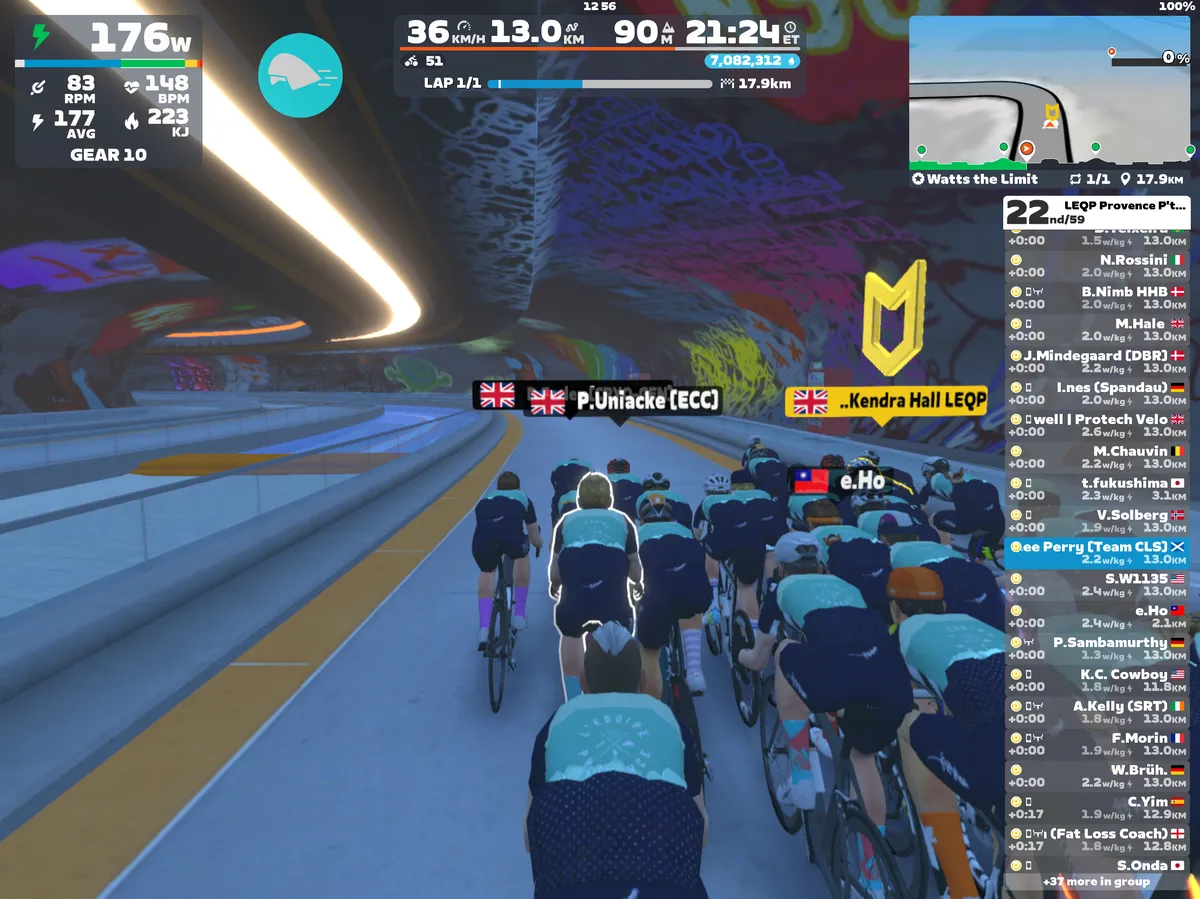 Screenshot from Zwift showing cyclists avatars riding through a tunnel with bright grafiti