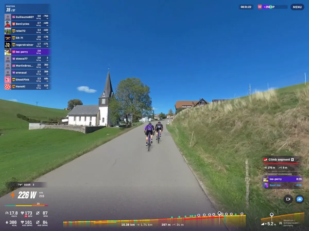 Cyclists' avatars ride past a white church under blue skies