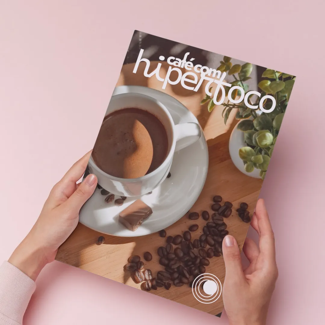 Hands holding the Café com Hiperfoco magazine