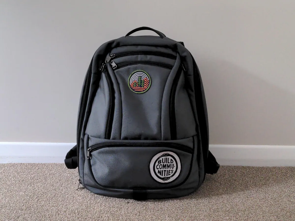 my perpetual travel onebag backpack. a simple thirty liter with two patches. one patch is a tree in a forest. the other patch is the slogan 