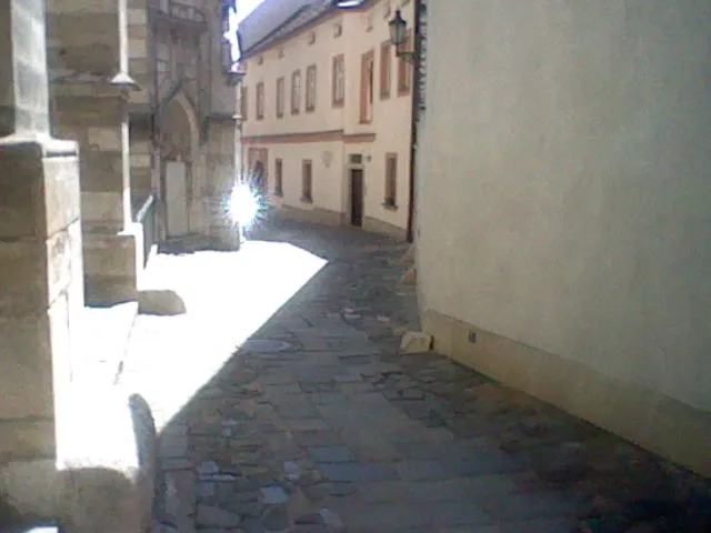 back alley behind a church in Brno, very yellow vibes, very bright, glare from reflected sun
