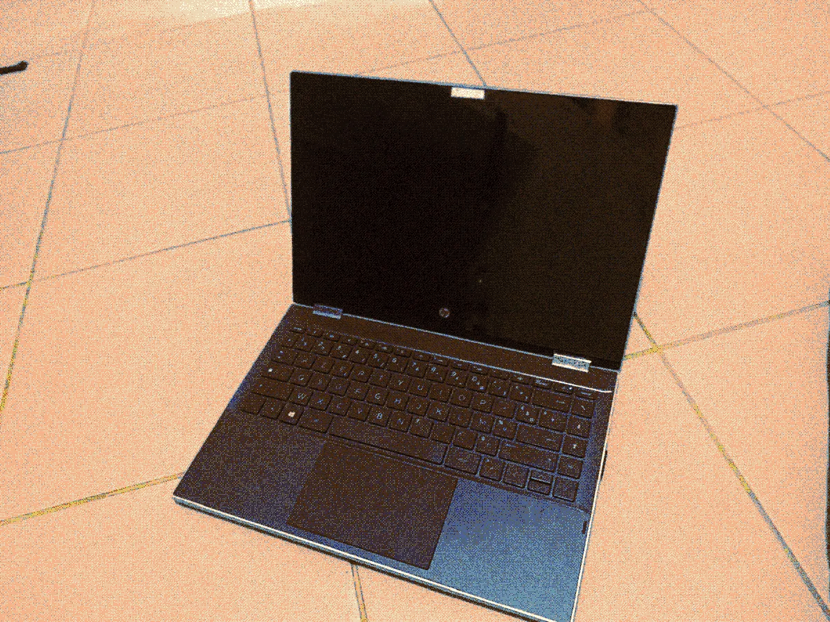 Image of the laptop named psychetron. The laptop is opened on the floor. The laptop seem a bit scratched at places but it's well taken care of.