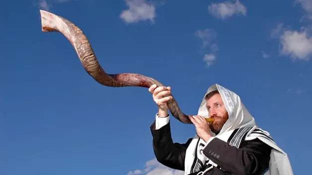 上图:一个犹太人于犹太新年吹响公羊角制成的羊角号(shofar)。犹太人被掳巴比伦回归以后,吹角节成为犹太人的农历新年(Rosh Hashanah),这一天要一百次吹响羊角号。