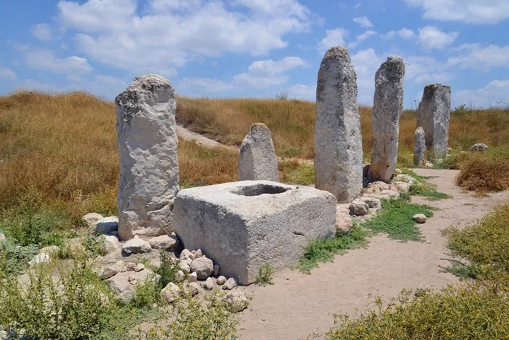 上图:考古学家在基色迦南人的圣所中发现了十根石柱,方石墩上的圆孔可能是用来立“木偶”的。在迦南宗教中,石柱代表生殖崇拜中的男神,被称为“柱像”。树木代表女神,被称为“木偶”或“亚舍拉柱”。男神和女神的名字及和相互之间的关系,不同地方的迦南人有不同的说法。男神的名字通常是“巴力 Baal),但不同的地方又有地方特色,如“巴力·毗珥”、“巴力·比利土”、“巴力·西卜”,统称“诸巴力 Baals”。女神的名字有的地方叫“亚纳特 Anath”、有的地方叫“亚舍拉 Asheroth”、有的叫“亚斯她录 Ashtaroth”,有的地方认为她是巴力的妻子、有的地方认为她是巴力的母亲。