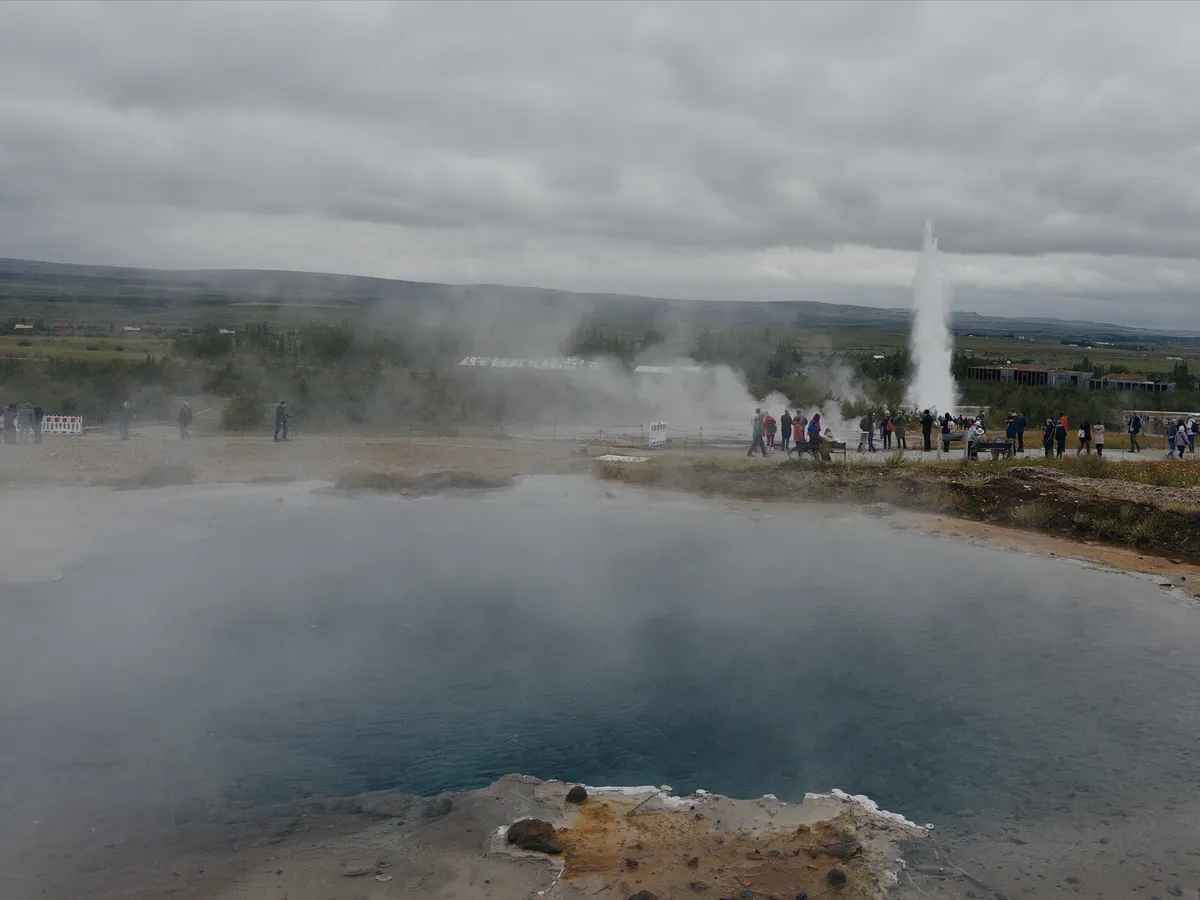 Geyser behind a steaming pool