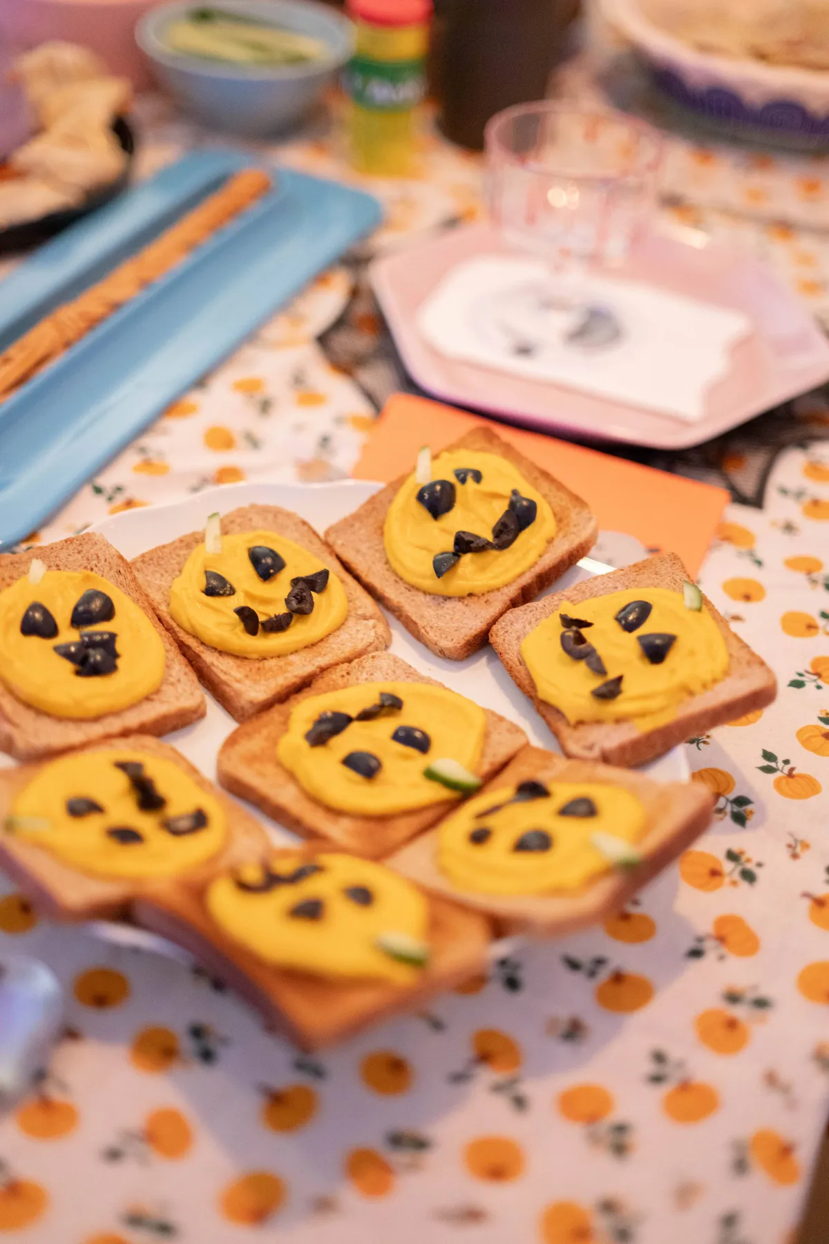 A plate filled with toasted bread decorated with jack-o-lantern faces.