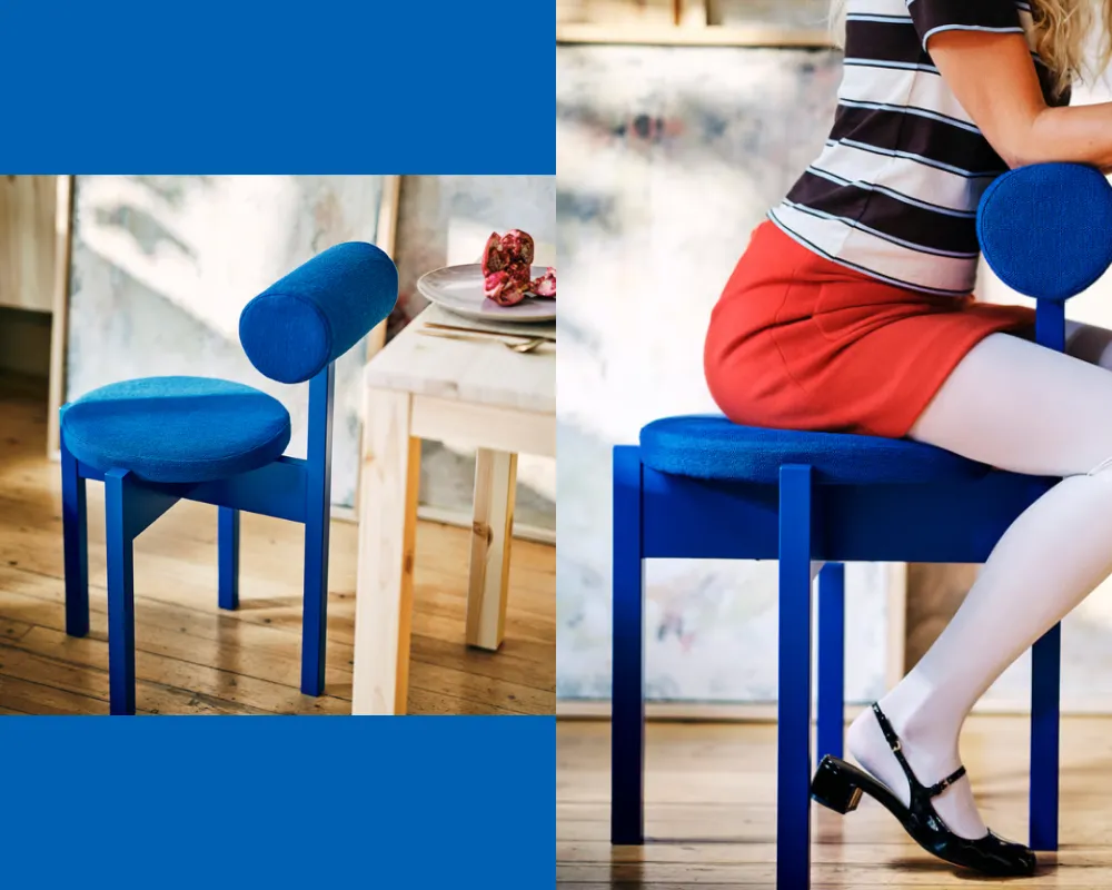 A bright blue chair with a round seat and a horizontal, cylindrical back. The user can also sit backwards on the chair, with their body leaning against the cylindrical back.