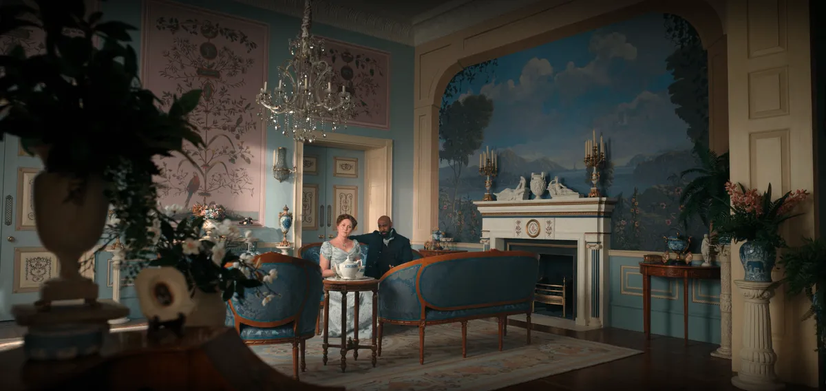 A beautiful parlor room with trompe l'œil painted walls depicting a majestic landscape.