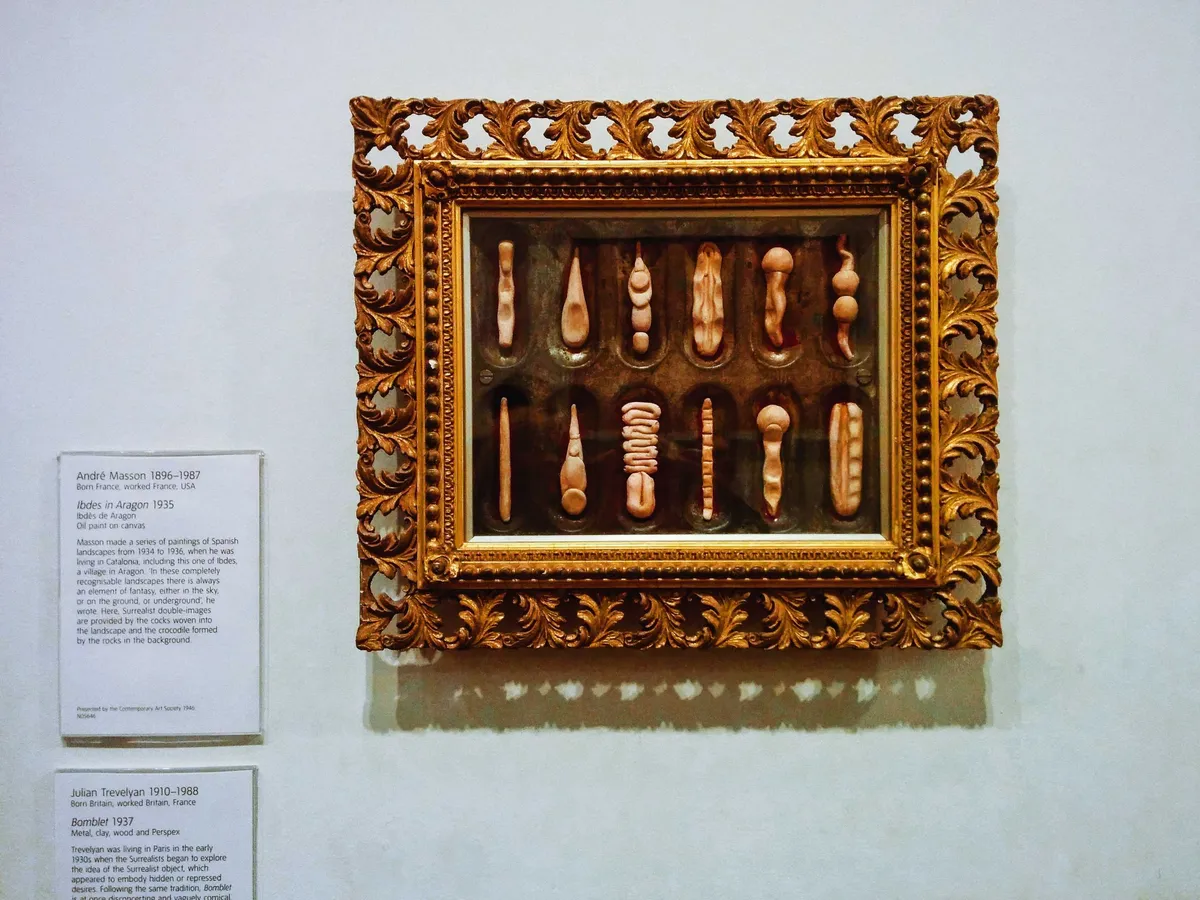A row of seashell-like objects incased in an ornate brass frame.