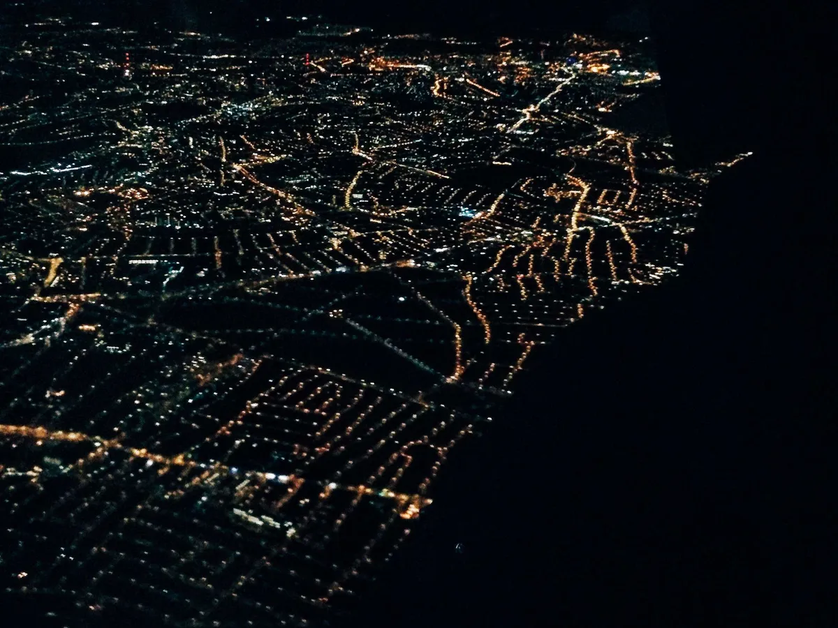 View of London from the airplane at night, so the city is lit up like stars against a black sky.