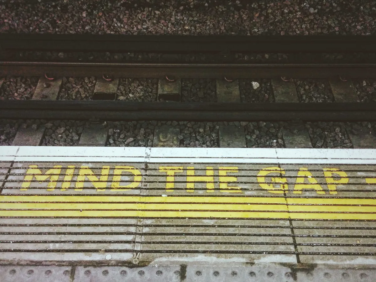 The edge of the train platform that say, "Mind the gap."