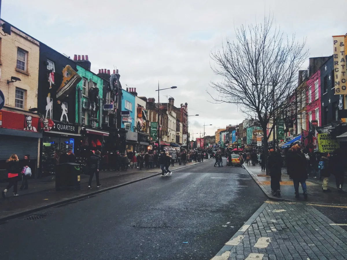 A street filled with vibrant shops and bustling with tourists.