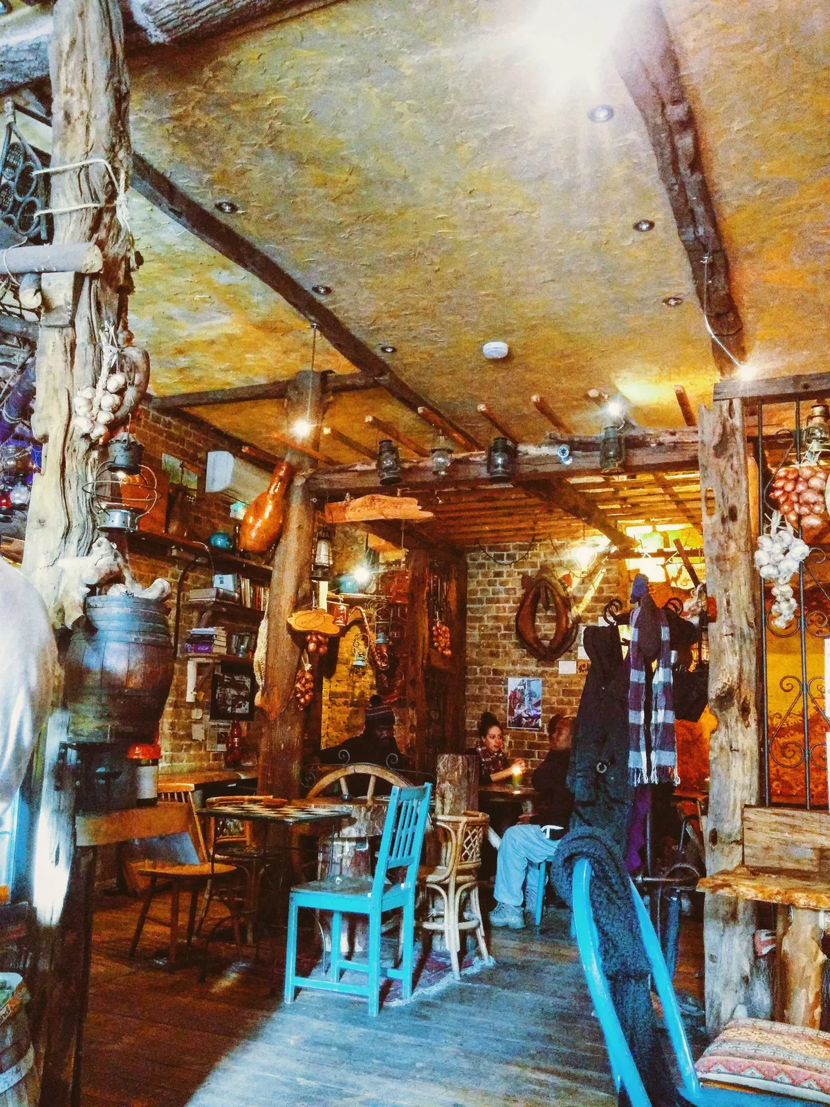 The interior of the café is made of natural wood with gnarled beams. Garlic and other herbs hang from the ceiling.