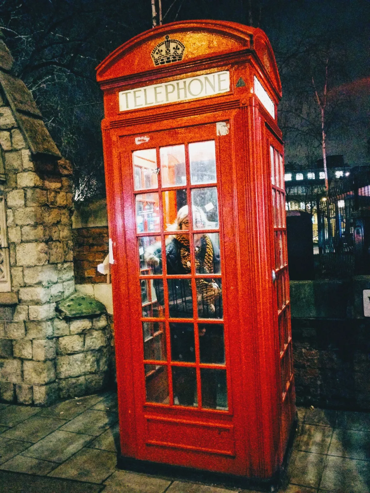 Peige inside a red phone booth.