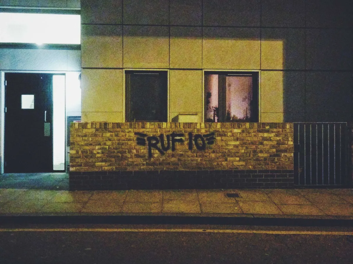 A low brick wall that has been spraypainted with the name 