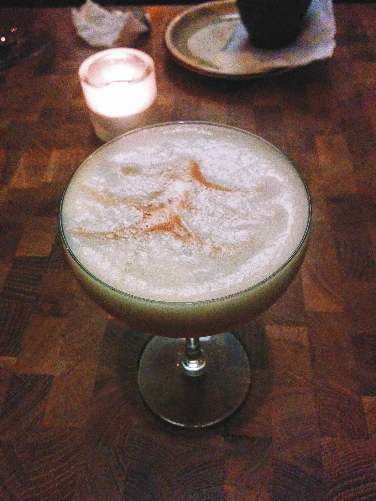 A champagne coupe with whiskey sour, with foamy egg white.