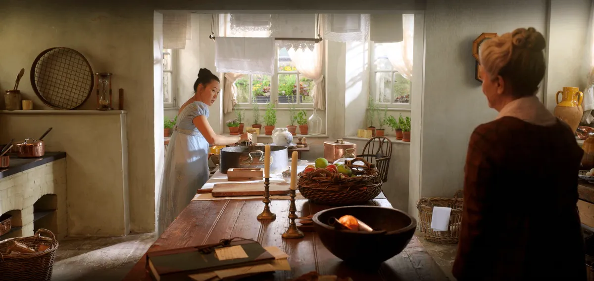 Sophie washing dishes inside My Cottage's kitchen.