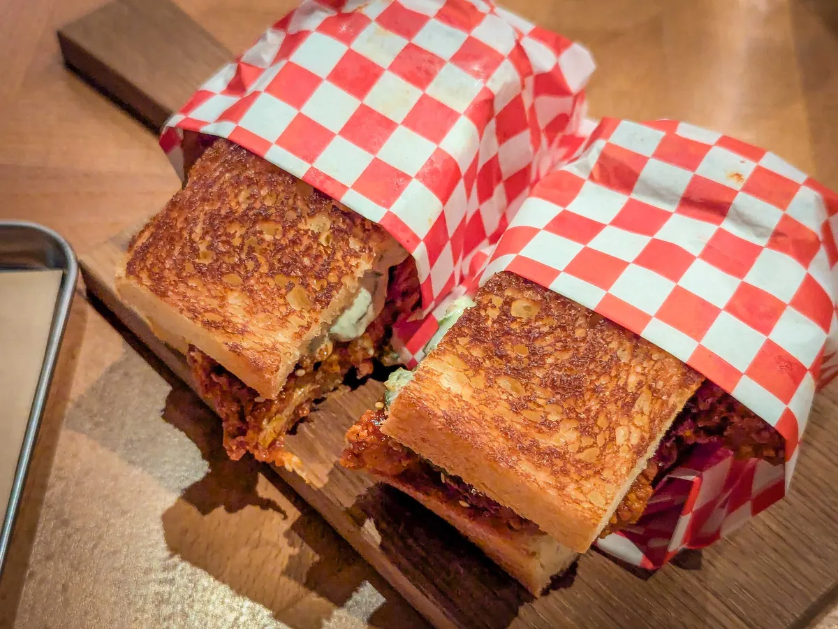 Two sandwich halves wrapped in red-white checkered paper.