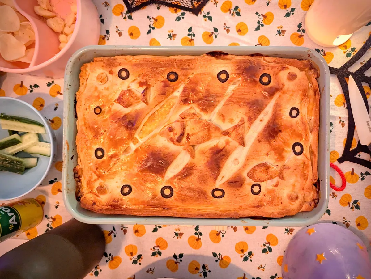 A rectangular pie decorated with sliced black olives for "bubbles" and a fish made out of dough. The top is a nice golden brown.