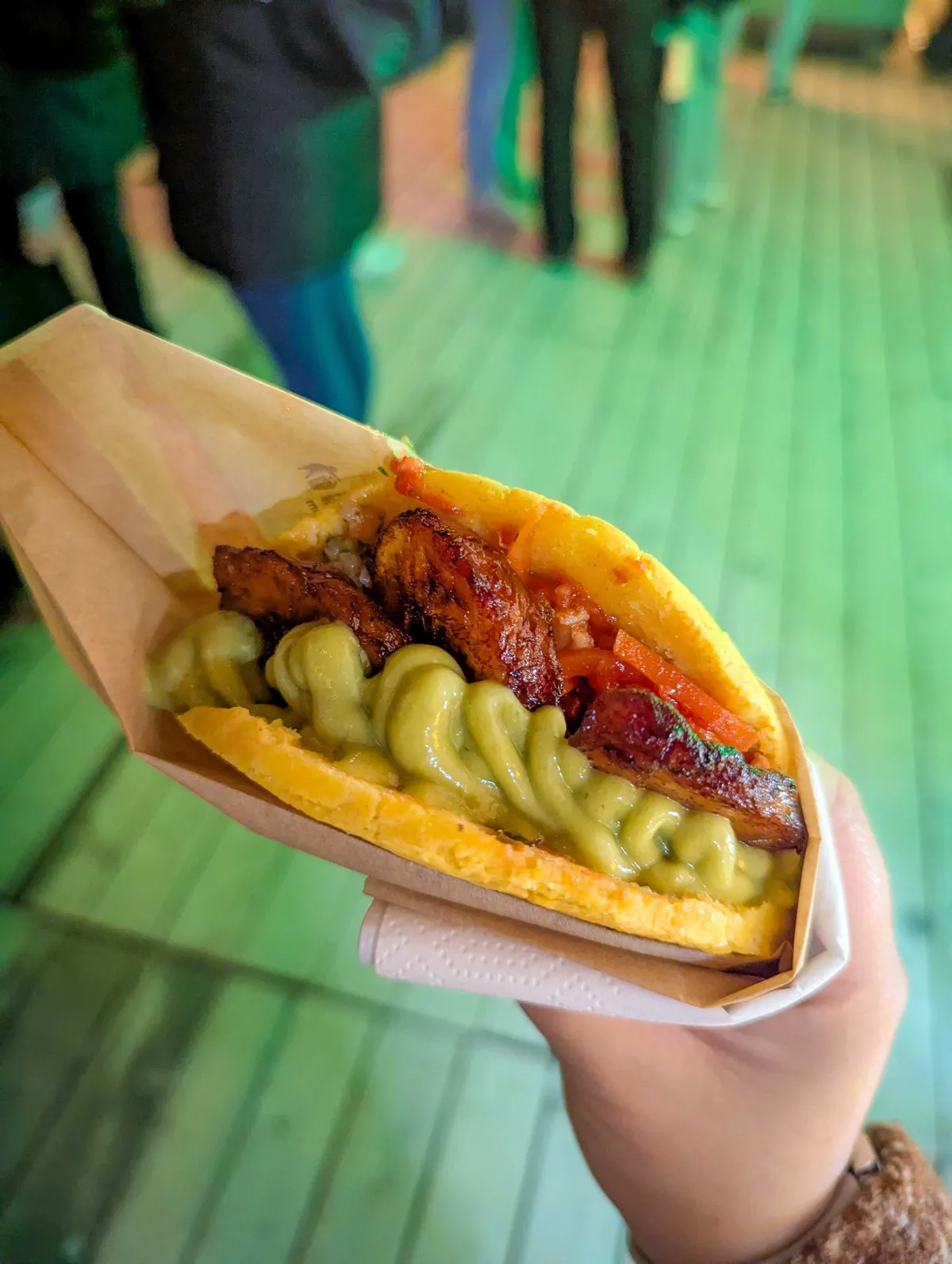 Peige holds an arepa stuffed with chicken and guacamole.