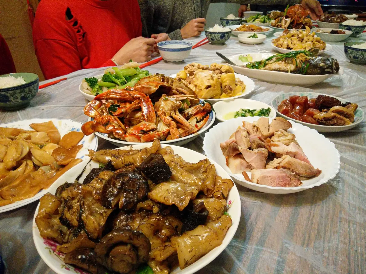 A table filled with teeming plates of food, mostly meat.