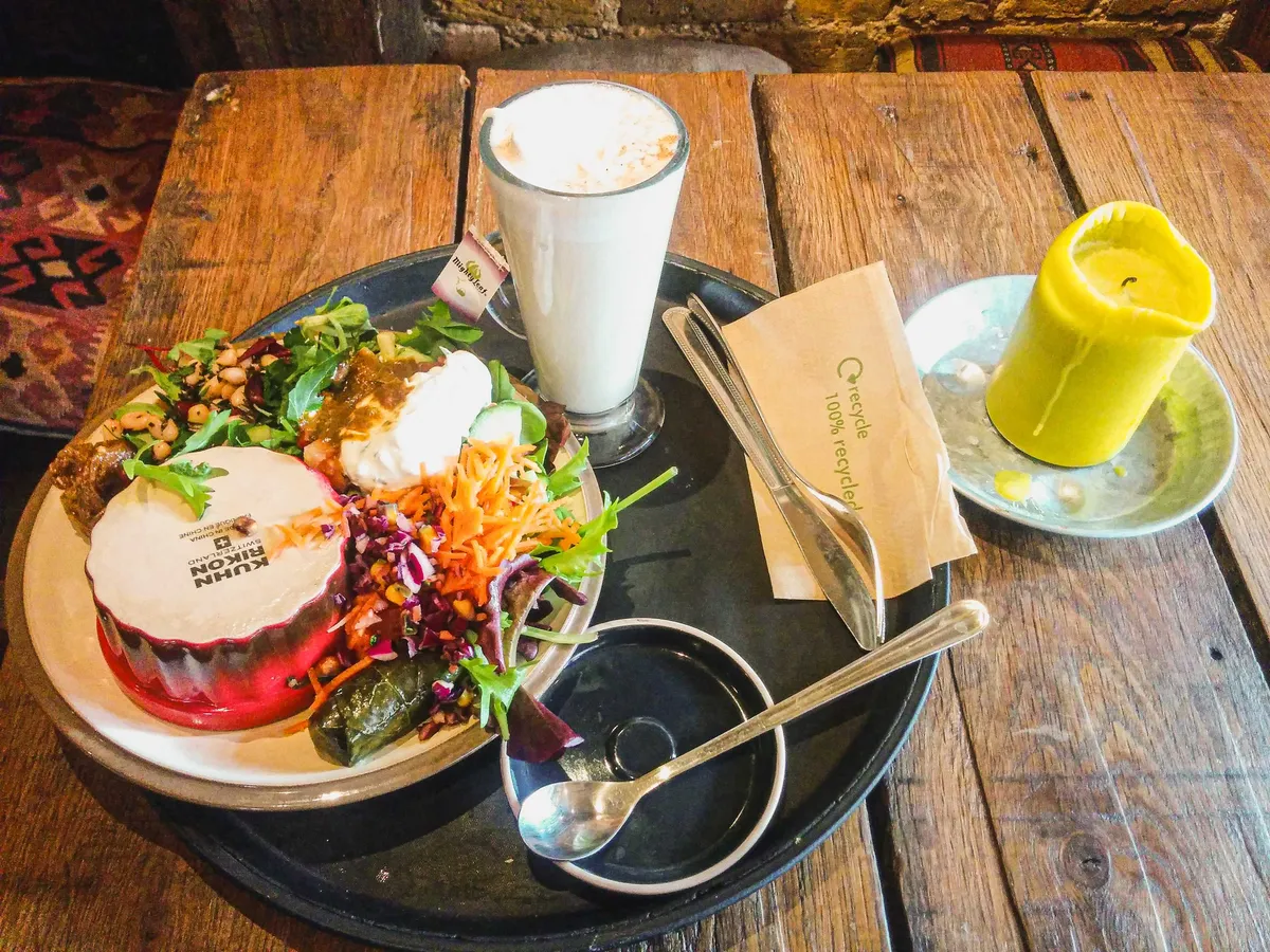 A Mediterranean vegan plate with a chai latte.
